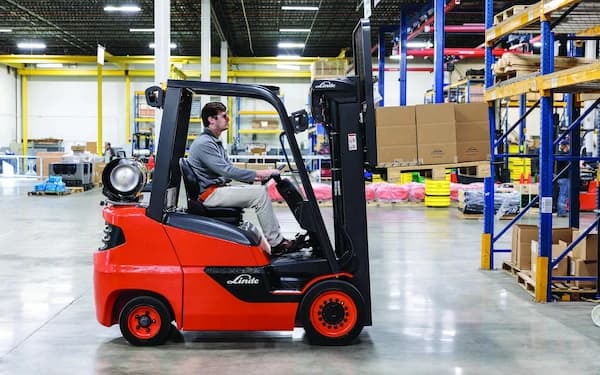 Red Linde forklift with an operator in a warehouse
